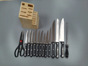 Bloc en bois de 13 couteaux de cuisine et une paire de ciseaux.